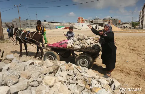 Palestinian woman Jihan Abu Muhsen collects bricks for sale with her son Mohammad from the ruins of a house destroyed during the 2014 war in Khan Younis in the southern Gaza Strip March 17, 2016. Abu Muhsen gathers brick...