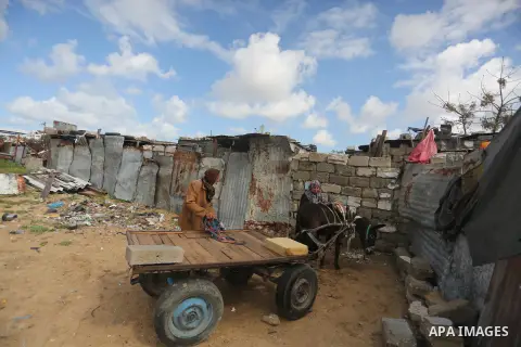 Palestinian woman Jihan Abu Muhsen prepares her donkey with her son Kareem before going work collecting bricks for sale from sites of demolished buildings, at her dwelling in Khan Younis in the southern Gaza Strip March...