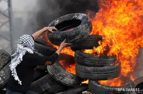 Palestinian protesters burn tires during clashes with Israeli security forces following a demonstration against the expropriation of Palestinian land by Israel in the village of Kfar Qaddum, near Nablus, in the occupied...