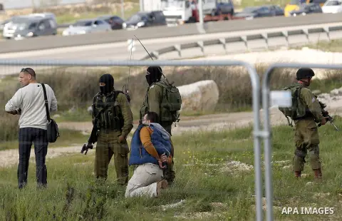 Israeli security forces detain a Palestinian journalist near the scene where a Palestinian, who the Israeli military said tried to stab soldiers, was shot dead at Gush Etzion junction, south of the West Bank city of Beth...
