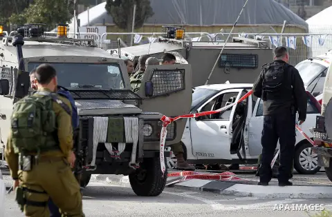 Israeli security forces inspect the scene where a Palestinian, who the Israeli military said tried to stab soldiers, was shot dead at Gush Etzion junction, south of the West Bank city of Bethlehem March 18, 2016. Photo b...