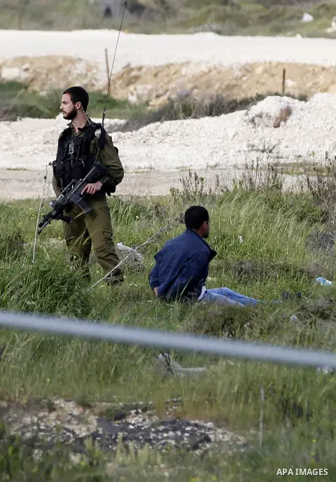 Israeli security forces detain a Palestinian journalist near the scene where a Palestinian, who the Israeli military said tried to stab soldiers, was shot dead at Gush Etzion junction, south of the West Bank city of Beth...