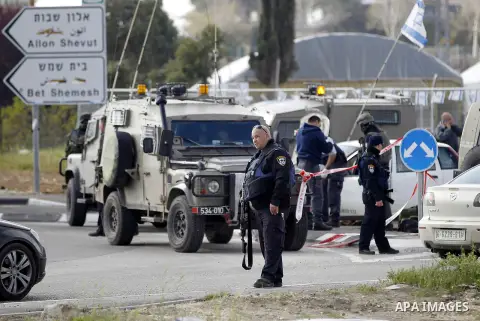 Israeli security forces inspect the scene where a Palestinian, who the Israeli military said tried to stab soldiers, was shot dead at Gush Etzion junction, south of the West Bank city of Bethlehem March 18, 2016. Photo b...