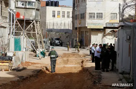 Israeli security forces gather near the scene where a Palestinian youth was shot near the Ibrahimi mosque, or the Tomb of the Patriarch, a religious site to both Muslims and Jews, in the Israeli occupied West Bank city o...