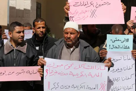 Palestinians who beneficiaries from Kuwaiti grant hold placards during a protest demanding to reconstruction of their homes which destroyed during 2014 war in Gaza city on March 20, 2016. Photo by Mohammed Asad