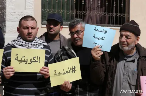 Palestinians who beneficiaries from Kuwaiti grant hold placards during a protest demanding to reconstruction of their homes which destroyed during 2014 war in Gaza city on March 20, 2016. Photo by Mohammed Asad