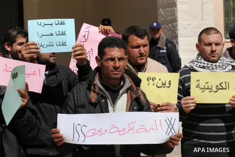 Palestinians who beneficiaries from Kuwaiti grant hold placards during a protest demanding to reconstruction of their homes which destroyed during 2014 war in Gaza city on March 20, 2016. Photo by Mohammed Asad