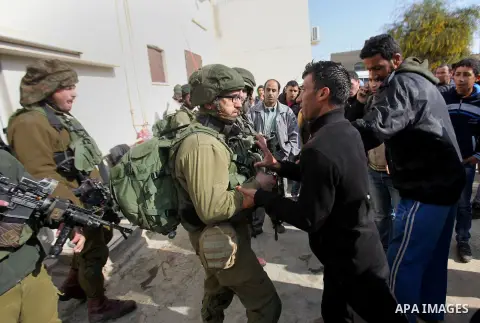 Israeli soldiers scuffle with a Palestinian man near the house of Ibrahim Dawabsheh, the main witness in the July arson attack that killed a Palestinian family, in the Israeli occupied West Bank village of Duma near Nabl...