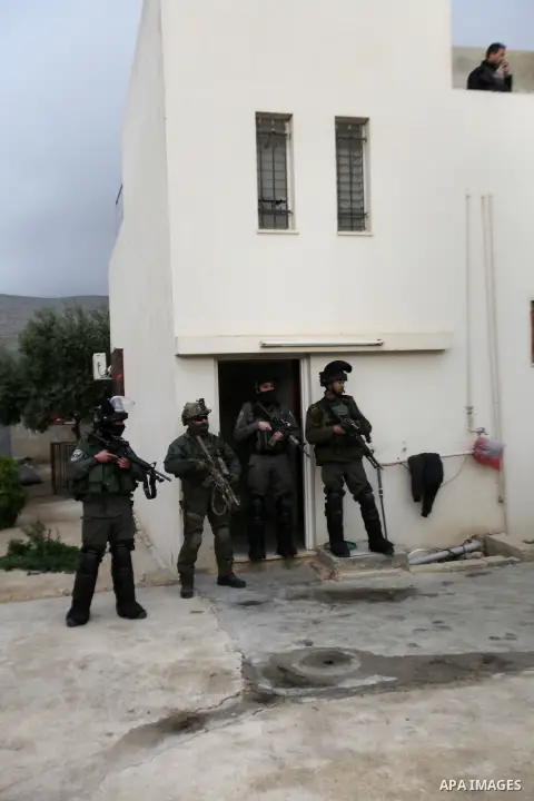 Israeli security forces stand guard outside a Palestinian burnt-out house belonging to a key witness to an arson attack which took place last year by Jewish extremists that killed a Palestinian family, in the Israeli occ...