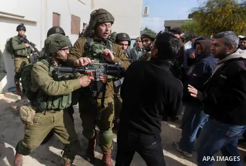 Israeli soldiers scuffle with a Palestinian man near the house of Ibrahim Dawabsheh, the main witness in the July arson attack that killed a Palestinian family, in the Israeli occupied West Bank village of Duma near Nabl...