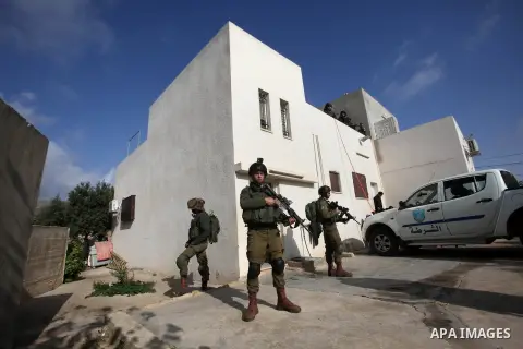 Israeli security forces stand guard outside a Palestinian burnt-out house belonging to a key witness to an arson attack which took place last year by Jewish extremists that killed a Palestinian family, in the Israeli occ...