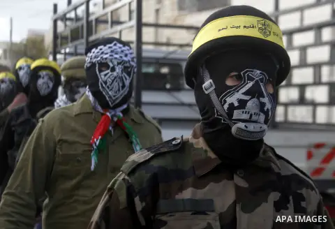Masked Palestinians march during the funeral of Ali Taqatqa and Ali Thawabteh, who the Israeli military said were shot dead by Israeli troops after they stabbed and wounded an Israeli soldier on Thursday outside a Jewish...