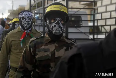 Masked Palestinians march during the funeral of Ali Taqatqa and Ali Thawabteh, who the Israeli military said were shot dead by Israeli troops after they stabbed and wounded an Israeli soldier on Thursday outside a Jewish...