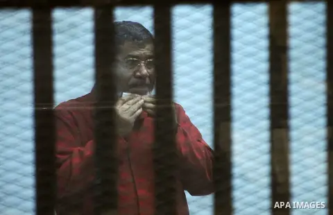 Ousted Egyptian president Mohammed Morsi sits behind bars during his trail as part of the so-called 'Qatar espionage' case, in a court in Cairo on March 21, 2016. The defendants are accused of 'leaking important national...