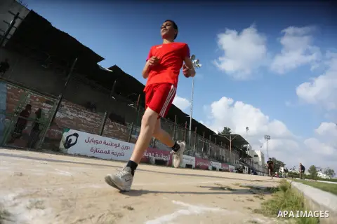 Palestinian youths take part in a local running championship at Yarmouk Stadium in Gaza city on March 21, 2016. Photo by Mohammed Asad