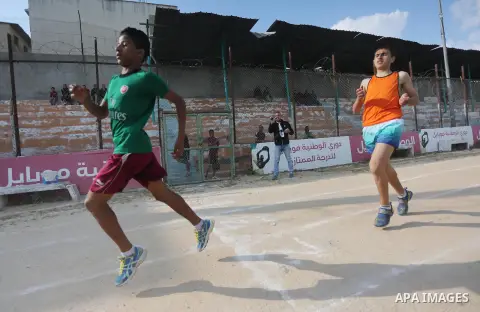 Palestinian youths take part in a local running championship at Yarmouk Stadium in Gaza city on March 21, 2016. Photo by Mohammed Asad