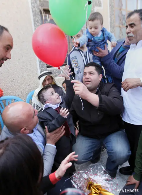 Palestinian boy Ahmed Dawabsha, 5, who suffered severe burns in an arson attack by suspected Jewish attackers on his family home last July and in which his younger brother, Ali, and his parents both died, is welcomed by...