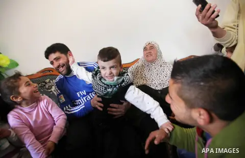 Palestinian boy Ahmed Dawabsha, 5, who suffered severe burns in an arson attack by suspected Jewish attackers on his family home last July and in which his younger brother, Ali, and his parents both died, is welcomed by...