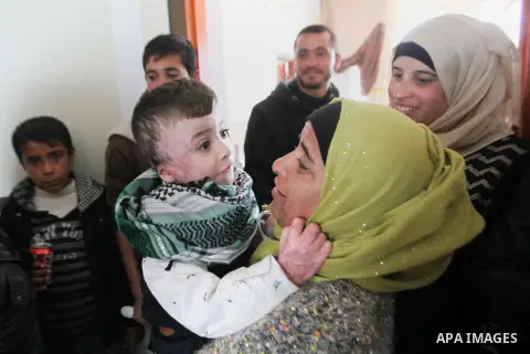 Palestinian boy Ahmed Dawabsha, 5, who suffered severe burns in an arson attack by suspected Jewish attackers on his family home last July and in which his younger brother, Ali, and his parents both died, is welcomed by...