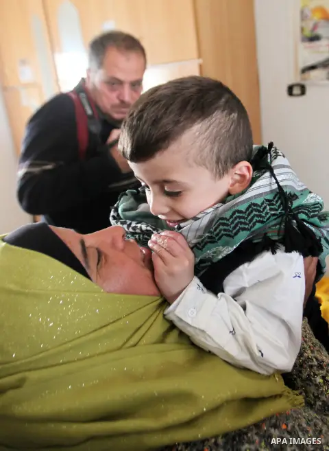 Palestinian boy Ahmed Dawabsha, 5, who suffered severe burns in an arson attack by suspected Jewish attackers on his family home last July and in which his younger brother, Ali, and his parents both died, is welcomed by...