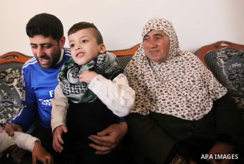 Palestinian boy Ahmed Dawabsha, 5, who suffered severe burns in an arson attack by suspected Jewish attackers on his family home last July and in which his younger brother, Ali, and his parents both died, is welcomed by...