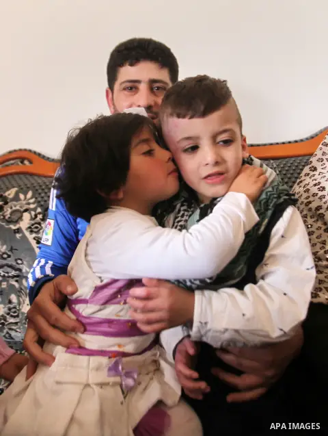 Palestinian boy Ahmed Dawabsha, 5, who suffered severe burns in an arson attack by suspected Jewish attackers on his family home last July and in which his younger brother, Ali, and his parents both died, is welcomed by...