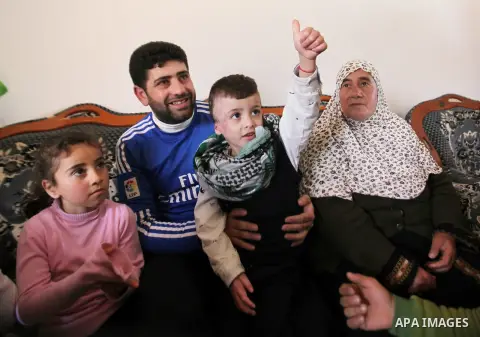Palestinian boy Ahmed Dawabsha, 5, who suffered severe burns in an arson attack by suspected Jewish attackers on his family home last July and in which his younger brother, Ali, and his parents both died, is welcomed by...
