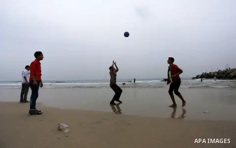 Palestinian children play volleyball at the beach of the Mediterranean sea on the coast of Gaza city, on March 25, 2016. Photo by Yasser Qudih