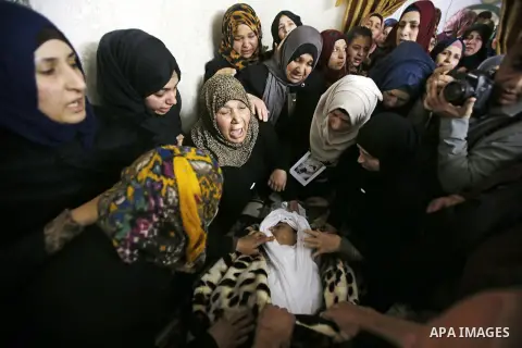 Relatives mourn next the body of Ramzi al-Qasrawi, 21, a Palestinian man who was killed in a reported stabbing attack, during his funeral in the West Bank town of Hebron on March 26, 2016. Ramzi al-Qasrawi was killed on...