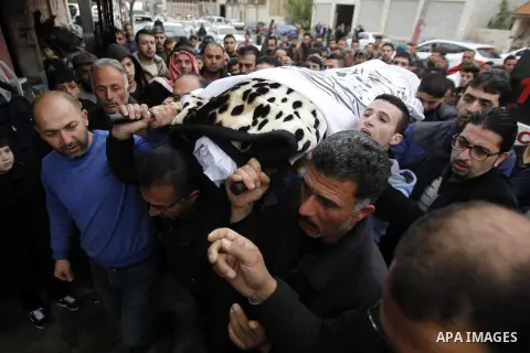 Relatives mourn next the body of Ramzi al-Qasrawi, 21, a Palestinian man who was killed in a reported stabbing attack, during his funeral in the West Bank town of Hebron on March 26, 2016. Ramzi al-Qasrawi was killed on...