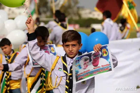 Palestinian chlidren hold ballons and posters bearing a portrait of Palestinian boy Ahmed Dawabsha, 5, who suffered severe burns in an arson attack by suspected Jewish attackers on his family home last July and in which...