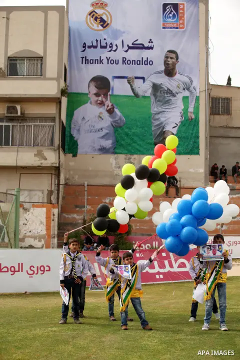 Palestinian chlidren hold ballons and posters bearing a portrait of Palestinian boy Ahmed Dawabsha, 5, who suffered severe burns in an arson attack by suspected Jewish attackers on his family home last July and in which...