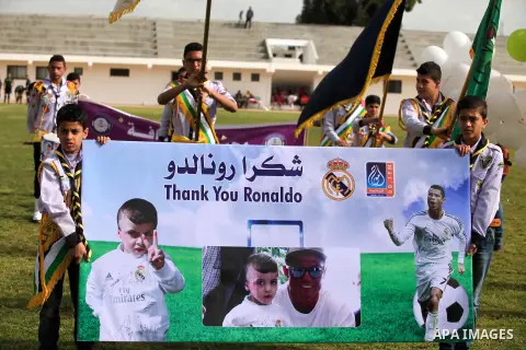 Palestinian chlidren hold ballons and posters bearing a portrait of Palestinian boy Ahmed Dawabsha, 5, who suffered severe burns in an arson attack by suspected Jewish attackers on his family home last July and in which...