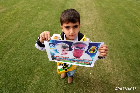 Palestinian chlidren hold ballons and posters bearing a portrait of Palestinian boy Ahmed Dawabsha, 5, who suffered severe burns in an arson attack by suspected Jewish attackers on his family home last July and in which...
