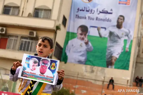 Palestinian chlidren hold ballons and posters bearing a portrait of Palestinian boy Ahmed Dawabsha, 5, who suffered severe burns in an arson attack by suspected Jewish attackers on his family home last July and in which...