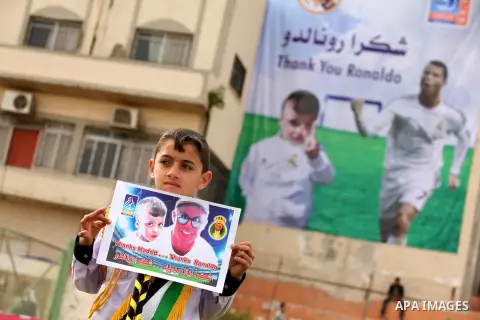Palestinian chlidren hold ballons and posters bearing a portrait of Palestinian boy Ahmed Dawabsha, 5, who suffered severe burns in an arson attack by suspected Jewish attackers on his family home last July and in which...