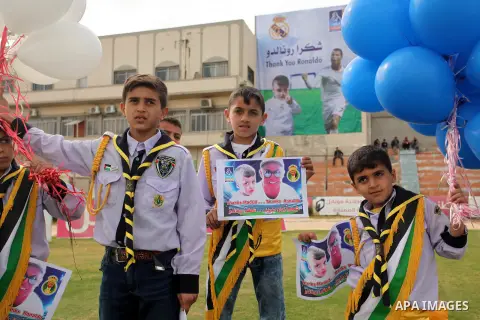 Palestinian chlidren hold ballons and posters bearing a portrait of Palestinian boy Ahmed Dawabsha, 5, who suffered severe burns in an arson attack by suspected Jewish attackers on his family home last July and in which...
