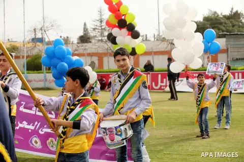 Palestinian chlidren hold ballons and posters bearing a portrait of Palestinian boy Ahmed Dawabsha, 5, who suffered severe burns in an arson attack by suspected Jewish attackers on his family home last July and in which...