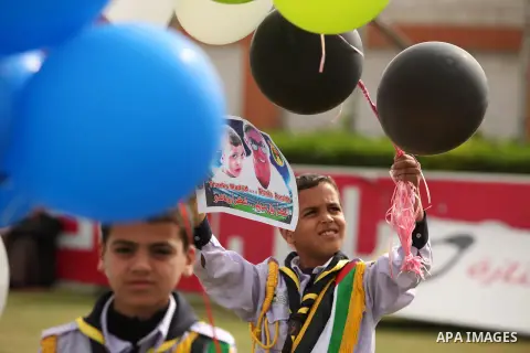 Palestinian chlidren hold ballons and posters bearing a portrait of Palestinian boy Ahmed Dawabsha, 5, who suffered severe burns in an arson attack by suspected Jewish attackers on his family home last July and in which...