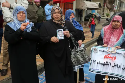Palestinian families of martyrs, hold banners during a protest to demand their salaries, in front of Red cross office, in Gaza city, on March 28, 2016. Photo by Mohammed Asad