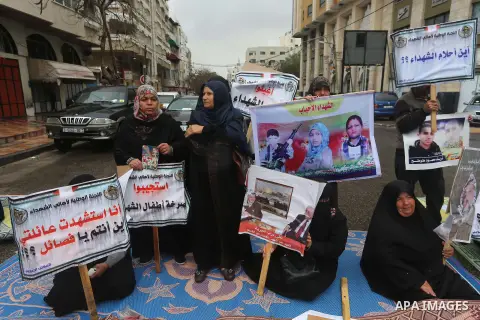 Palestinian families of martyrs, hold banners during a protest to demand their salaries, in front of Red cross office, in Gaza city, on March 28, 2016. Photo by Mohammed Asad