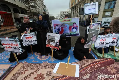 Palestinian families of martyrs, hold banners during a protest to demand their salaries, in front of Red cross office, in Gaza city, on March 28, 2016. Photo by Mohammed Asad
