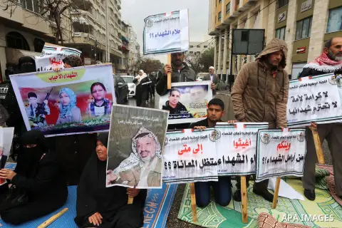 Palestinian families of martyrs, hold banners during a protest to demand their salaries, in front of Red cross office, in Gaza city, on March 28, 2016. Photo by Mohammed Asad