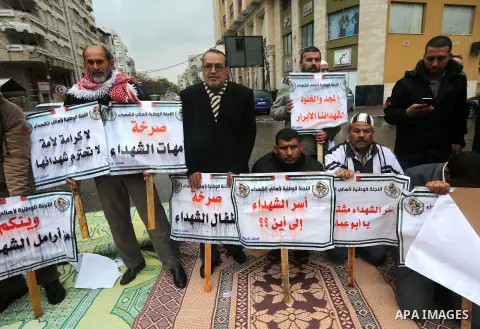 Palestinian families of martyrs, hold banners during a protest to demand their salaries, in front of Red cross office, in Gaza city, on March 28, 2016. Photo by Mohammed Asad