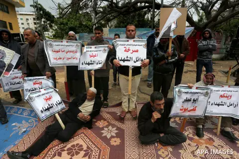Palestinian families of martyrs, hold banners during a protest to demand their salaries, in front of Red cross office, in Gaza city, on March 28, 2016. Photo by Mohammed Asad