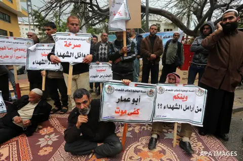 Palestinian families of martyrs, hold banners during a protest to demand their salaries, in front of Red cross office, in Gaza city, on March 28, 2016. Photo by Mohammed Asad
