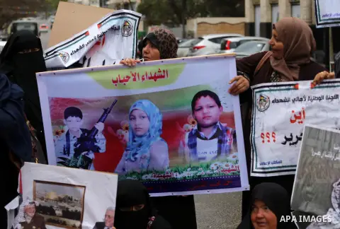 Palestinian families of martyrs, hold banners during a protest to demand their salaries, in front of Red cross office, in Gaza city, on March 28, 2016. Photo by Mohammed Asad
