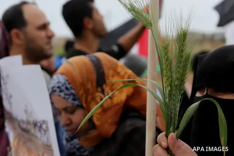 Palestinians hold national flags during a march to mark Land Day in Gaza, on March 29, 2016. The annual demonstrations mark the deaths of six Arab Israeli protesters at the hands of Israeli police and troops during mass...