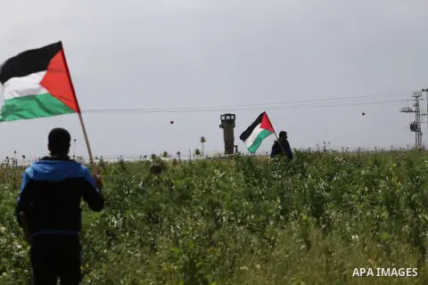 Palestinians hold national flags during a march to mark Land Day in Gaza, on March 29, 2016. The annual demonstrations mark the deaths of six Arab Israeli protesters at the hands of Israeli police and troops during mass...