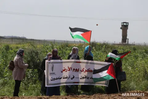 Palestinians hold national flags during a march to mark Land Day in Gaza, on March 29, 2016. The annual demonstrations mark the deaths of six Arab Israeli protesters at the hands of Israeli police and troops during mass...